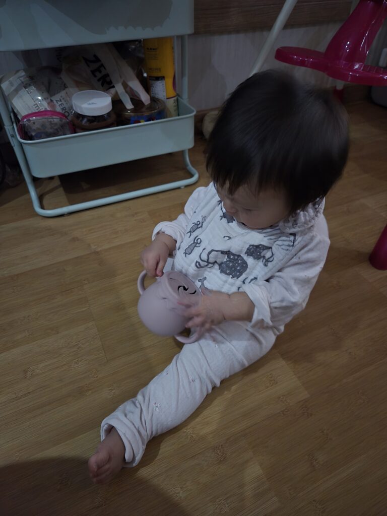 자기주도 간식 연습 중인 11개월 아기와 아기 스낵컵